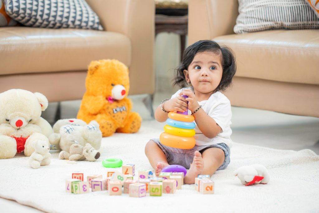 Indian,Baby,Sitting,On,Floor,Playing,With,His,Toys