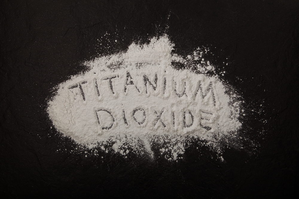 Titanium,Dioxide,Powder,Scattered,On,Black,Surface,With,Inscription,Titanium